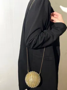 Close-up of sparkling rhinestone spherical evening clutch bag with metal chain strap detail.