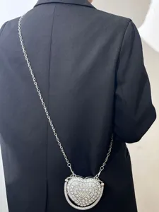 Detailansicht einer atemberaubenden herzförmigen Strass-Umhängetasche mit schicker Metallkette.
