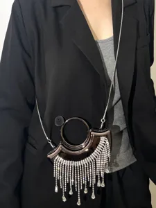 Detailansicht der metallischen Mini-Abendtasche mit funkelnden Strassfransen und Kette.