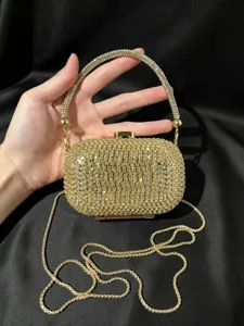 Detailansicht der luxuriösen goldenen Strass-Abendtasche mit glitzerndem Griff und Kette.