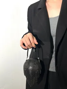Gros plan sur un sac de soirée sphérique en strass noirs étincelants avec franges.