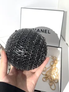Detailed close-up of the sparkling rhinestone ball evening bag showing crystal texture and chain.