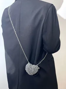 Detailaufnahme der Mini Strass Herz Umhängetasche an schwarzem Blazer, eleganter Stil.