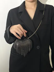 Gros plan sur le sac de soirée cœur en cristal noir avec franges délicates et chaîne.