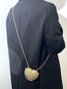 Detailansicht der Mini Herz Strass Kettentasche, glitzernde Kristalle mit goldenem Riemen.