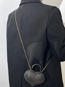 Vista dettagliata della mini borsa da sera a cuore con strass scintillanti e catena elegante.