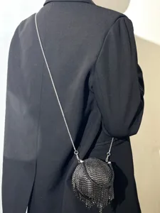 Détail sac de soirée strass franges noir, sac bandoulière rond élégant pour fête.