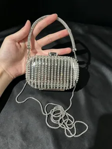 Detailaufnahme der funkelnden Strass-Abendtasche mit filigranen Metallkettendetails.