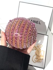 Sparkling rhinestone ball evening clutch bag with pink and gold crystals for women.
