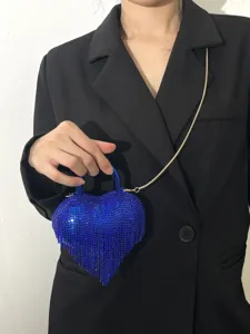 Détail du sac de soirée cœur en strass bleus, pochette bandoulière frangée scintillante.