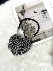 Nahaufnahme der glitzernden Strass-Herz-Abendtasche mit silberner Kette und Perlen.