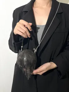 Vue détaillée du sac de soirée boule en strass noirs scintillants avec franges.