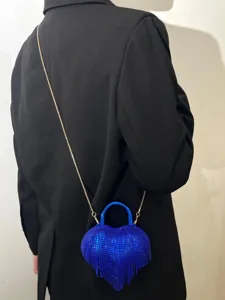 Sac de soirée cœur en strass bleu brillant avec franges et chaîne dorée élégante.