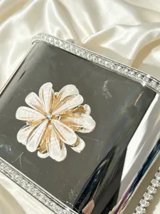 Dettaglio della borsa a mano in acrilico di lusso con fiore di perla e cornice di strass
