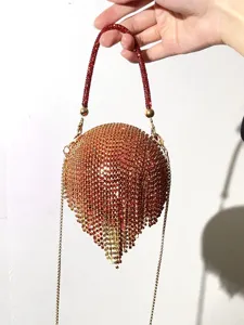 Détail sac de soirée à franges strass, pochette de fête scintillante cristaux or et rouge.