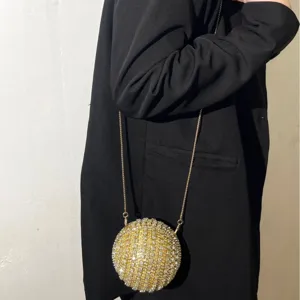 Sparkling rhinestone spherical evening bag with chic gold chain strap for women party.