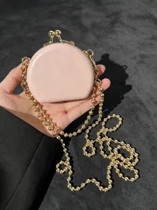 Detailweergave van mini roze PU lederen lipsticktas met gouden ketting schoudertas.