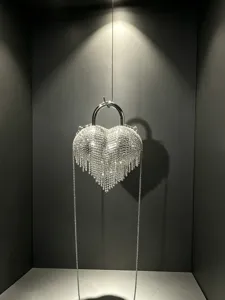 Sac à main de soirée en forme de cœur avec strass scintillants et franges élégantes.