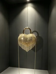 Élégant sac de soirée cœur en strass avec poignée en métal et franges scintillantes.