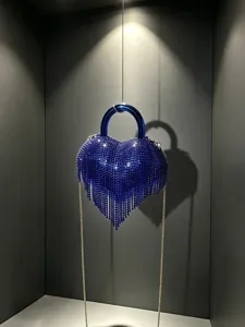 Vue détaillée d'un superbe sac de soirée cœur en strass bleu avec franges délicates.