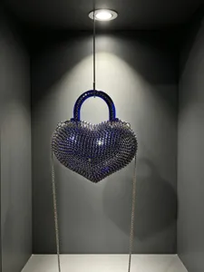 Primo piano della borsa da sera a cuore in cristallo brillante con manico e catena.