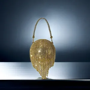Détail de sac de soirée étincelant en strass avec des cristaux brillants et un design de pampilles dorées.