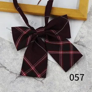 Detailed close-up of a maroon plaid JK bow tie, showing fabric texture and stylish pattern.