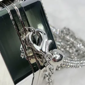 Nahaufnahme Detail der Acryl Abendtasche silberner Metallverschluss und Strass Kettenriemen