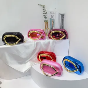 Detailed view of colorful acrylic evening clutches featuring unique sculptural gold metal handles.