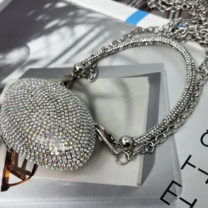 Detailaufnahme der glitzernden Strass Mini Umhängetasche mit silberner Kette und funkelnden Steinen.
