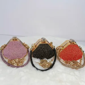 Sechseckige Strass-Abendtasche mit goldener Kette und edlem Metallverschluss im Detail.