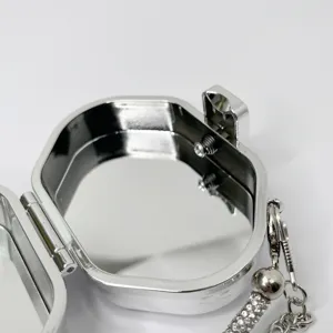 Nahaufnahme des silbernen Metall-Minitaschendetails mit glänzender Oberfläche und Strasskette.