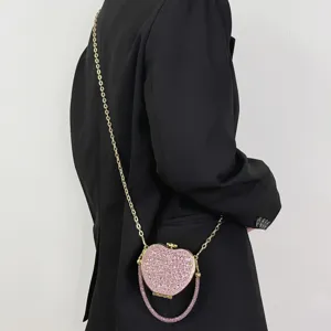 Detailansicht einer glitzernden pinken Strass Mini Herz Umhängetasche mit Metallkette.