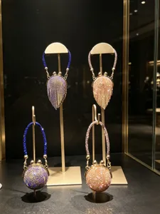 Detailansicht luxuriöser Mini-Kristall-Strass-Abendtaschen auf goldenen Ständern präsentiert.