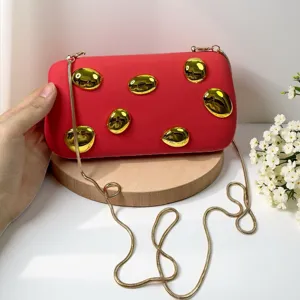 Elegante rote Clutch Tasche mit atemberaubenden goldenen Metall-Details und feiner Kette.