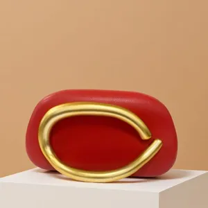 Red leather mini evening clutch bag with a bold retro gold-colored sculptural metal handle.