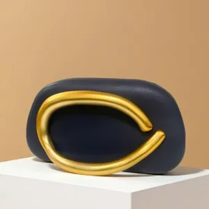 Elegant mini evening bag with bold gold metal ring handle, dark blue leather luxury clutch.