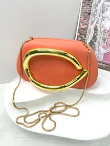 Elegant orange clutch bag with bold gold metallic handle and chain strap for evening events.