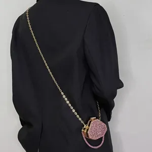 Glitzernde Mini Abendtasche Detailansicht, pinke Strass Clutch mit goldener Metallkette.