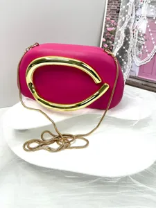 Stunning pink evening clutch bag with luxury gold chain strap and unique artistic metal handle.