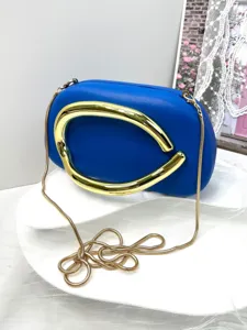 Blue leather clutch bag with striking gold handle and chain strap for women evening party.