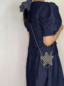 Vue détaillée d'un sac bandoulière élégant en métal en forme d'étoile avec des strass.