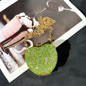 Detailansicht der grünen Strass Mini-Abendtasche mit funkelnden Kristallen und Goldkette.