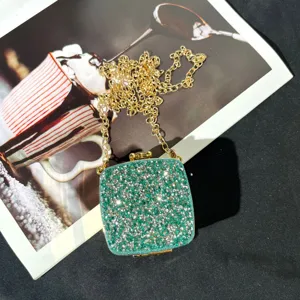 Detailansicht der grünen Strass-Abendtasche mit glitzernden Kristallen und goldener Kette.