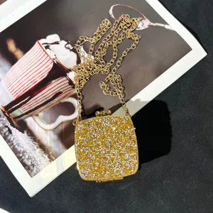 Nahaufnahme der glitzernden Strass-Abendtasche mit goldener Metallkettenschulterriemen.