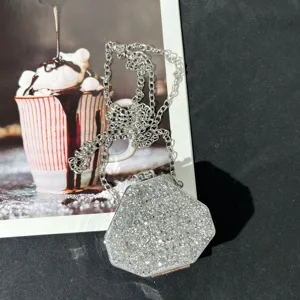 Detailansicht der glitzernden Mini-Abendtasche mit silberner Kette und Strasssteinen.