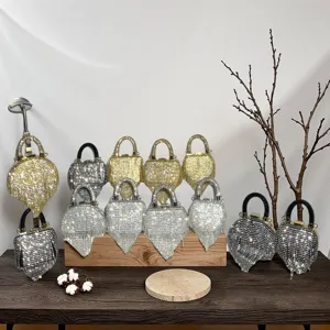Detailansicht glitzernder Kristall-Strass-Herz-Abendtaschen mit zarten Quasten.