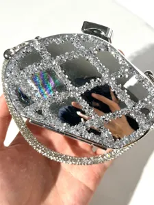 Silver rhinestone mini clutch bag with dazzling crystals and elegant mirror finish design.