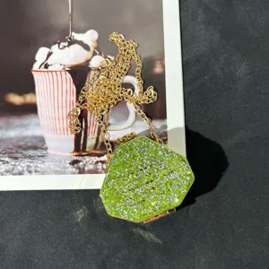 Detailaufnahme der grünen Strass-Mini-Abendtasche mit glänzenden Steinen und Goldkette.