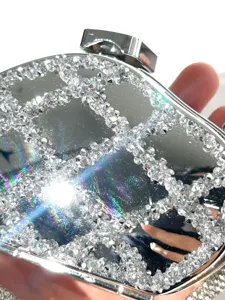 Close-up detail of rhinestone mirror acrylic clutch bag sparkling crystals lattice pattern.